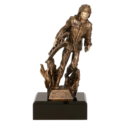 Statuetka odlewana RTYR3768 Strażak w Pożarze w kolorze brązu na ciemnej podstawie. Model przedstawia strażaka wśród płomieni i sprawdzi się jako nagroda, wyróżnienie lub podziękowanie dla strażaków. Miejsce na tabliczkę z nadrukiem.