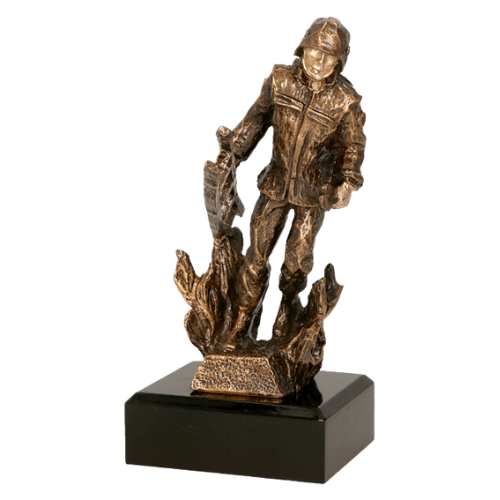 Statuetka odlewana RTYR3768 Strażak w Pożarze w kolorze brązu na ciemnej podstawie. Model przedstawia strażaka wśród płomieni i sprawdzi się jako nagroda, wyróżnienie lub podziękowanie dla strażaków. Miejsce na tabliczkę z nadrukiem.